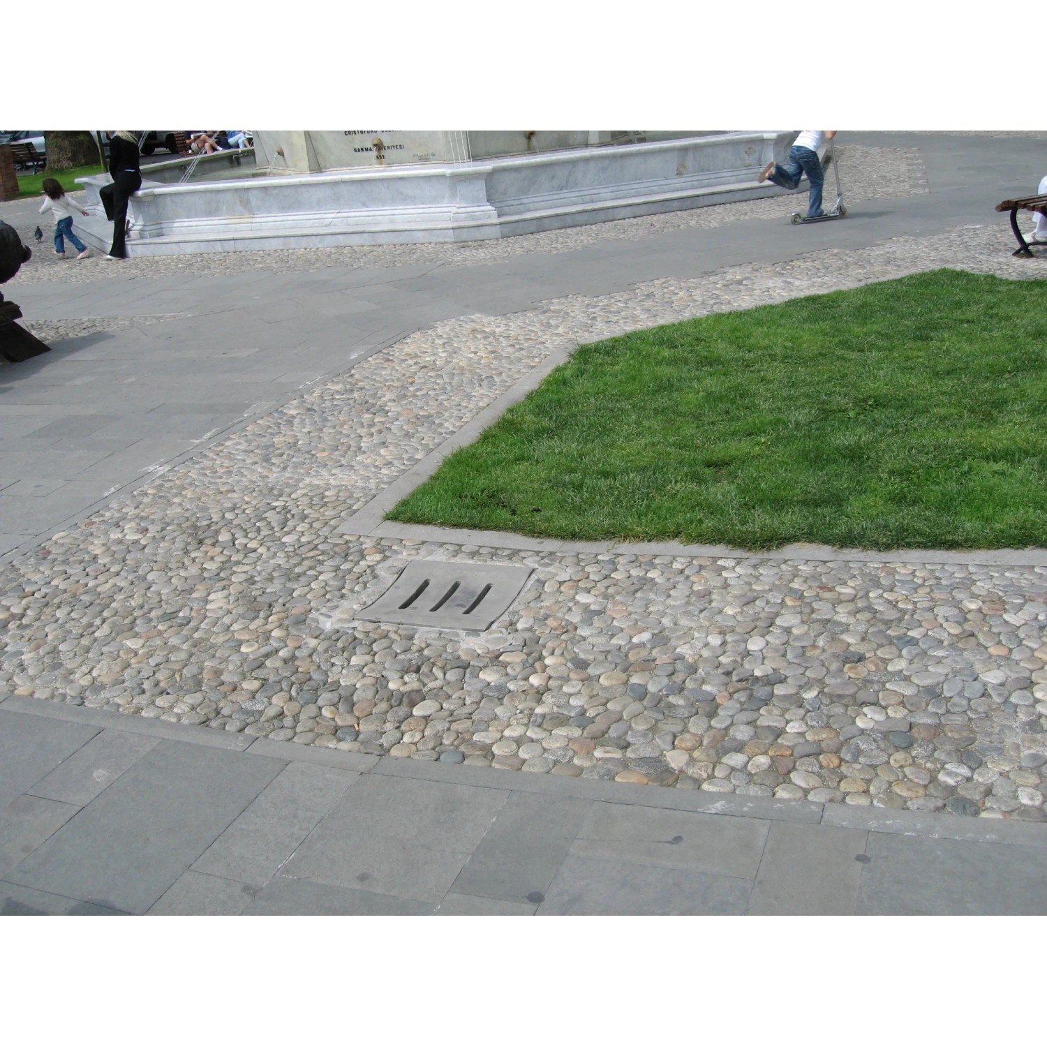 Pavimentazione con Ciottoli e Granulati, sentiero di ghiaia con prato e canale di drenaggio.