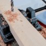 Dettaglio di un trapano a colonna t.b.t. che fora un pezzo di legno.