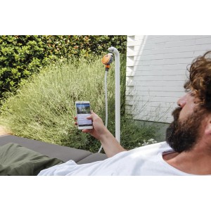 Uomo controlla l'irrigazione con l'app. t.b.t. della categoria Programmatori.