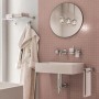 Bagno moderno con lavabo, specchio, portasciugamani e accessori per doccia.