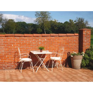 Set tavolo da giardino con due sedie davanti a un muro di mattoni.
