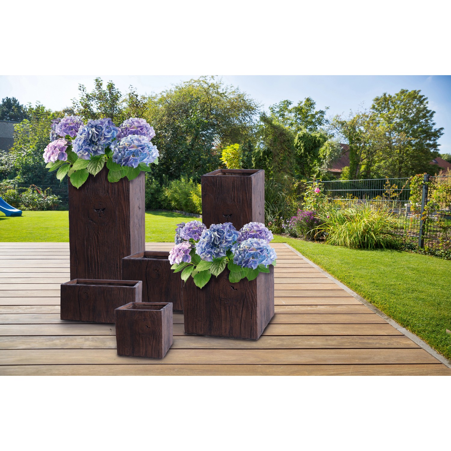 Fioriere in fibra di argilla marrone con texture legno, varie dimensioni, piantate con ortensie.