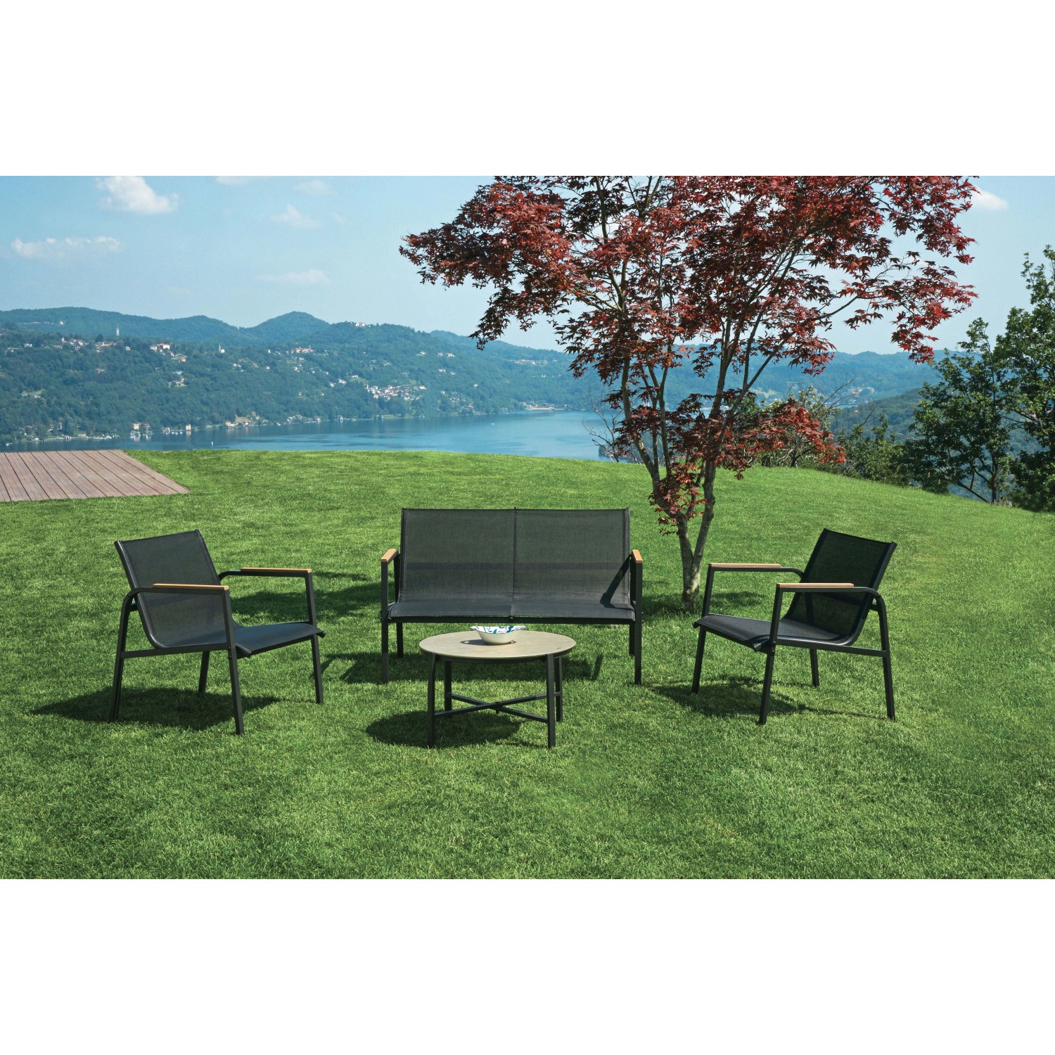 Set di mobili da giardino t.b.t. con divano, tavolo e due sedie su prato.