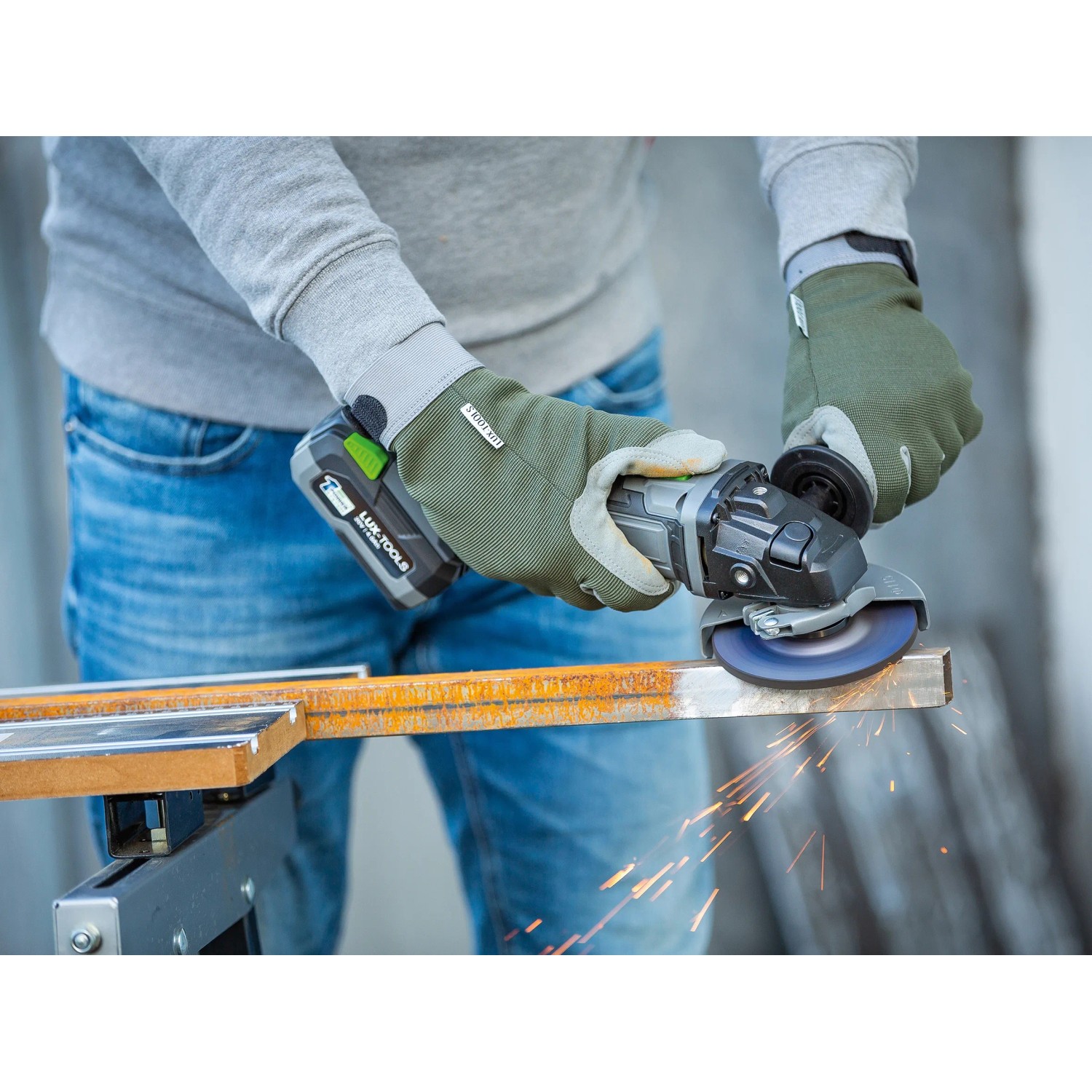Smerigliatrice angolare a batteria LUX A-WS-20/115 in uso durante la smerigliatura del metallo.