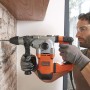 Trapano a percussione Black+Decker BEHS03K (1250 W) mentre fora un muro.