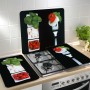 Set di 2 coperture per piano cottura Wenko Caprese su un fornello, con motivi di pomodori, mozzarella e basilico.