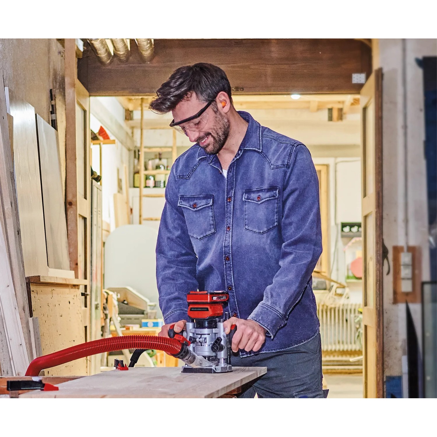 Uomo che lavora il legno con la fresatrice a batteria Einhell TP-RO 18 Li BL.