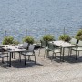 Due set di mobili da giardino t.b.t. con tavoli e sedie su una terrazza sul lago.