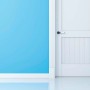 Dettaglio di una porta bianca su una parete blu.