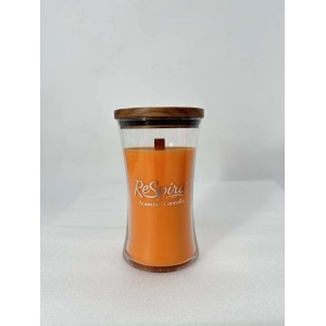 Candela profumata arancione in vetro con coperchio in legno. Candela cilindrica per un'atmosfera accogliente.