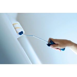 Rullo per pittura LUX Goldfaden XL con telaio e impugnatura morbida mentre dipinge una parete.