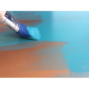 Pennello con vernice blu che dipinge una superficie. Accessori per dipingere.