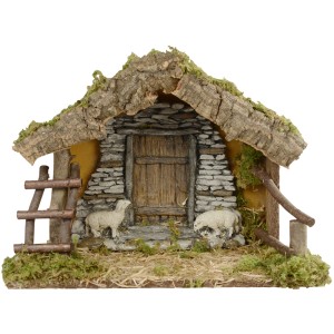 Stalla per presepe con facciata in pietra, porta in legno e due pecore per il presepe natalizio.