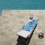 Piastrelle per esterni t.b.t. beige attorno alla piscina con lettino. Pavimentazione esterna.