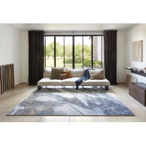 Tappeto moderno con motivo astratto nei toni del blu e del grigio nel soggiorno.