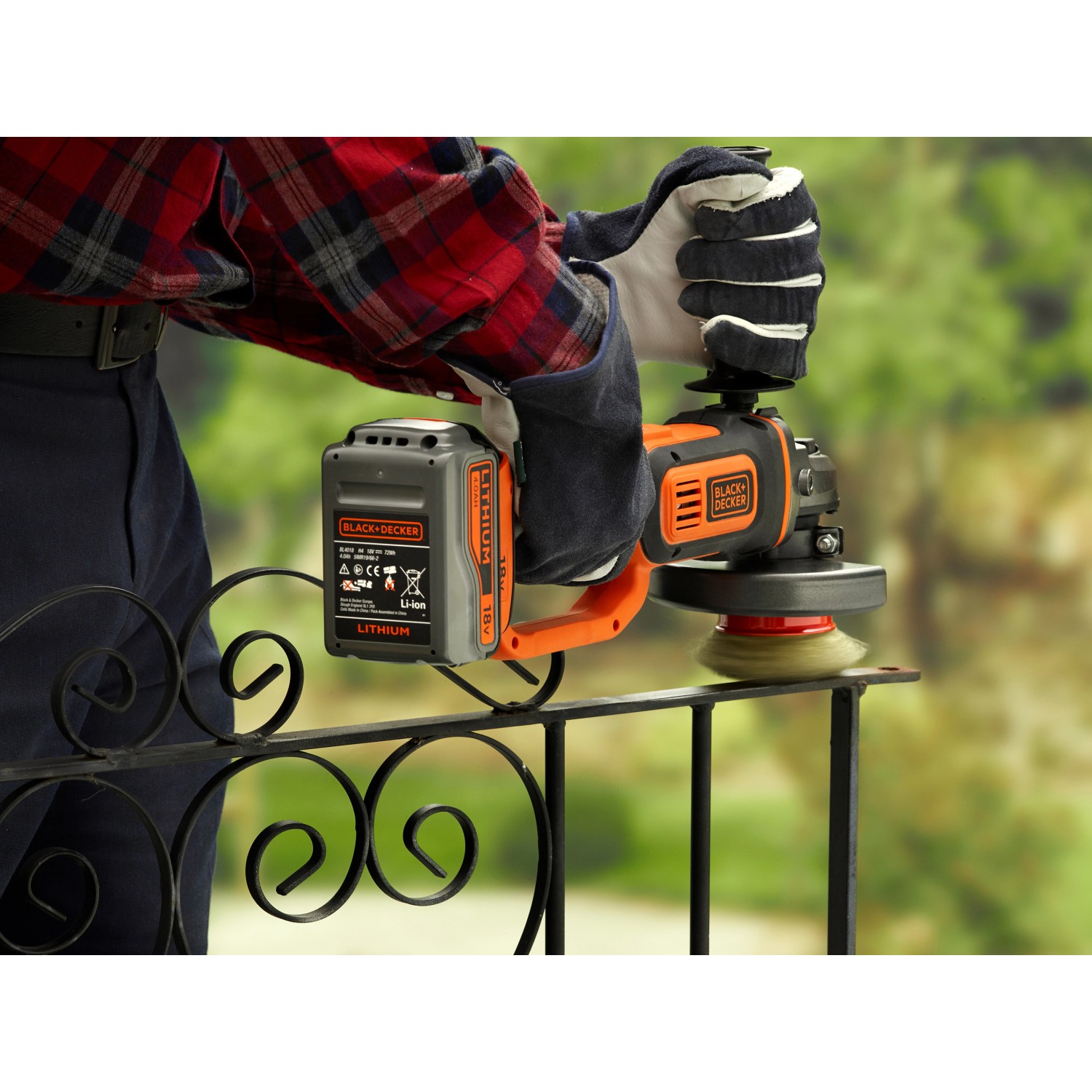 Smerigliatrice angolare a batteria Black+Decker 18V mentre leviga una ringhiera di metallo.