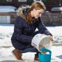 Donna riempie lo spargitore manuale Gardena M con materiale di spargimento. Ideale per sementi, fertilizzanti e sale.