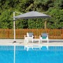 Ombrellone a braccio t.b.t. grigio accanto a piscina e mobili da giardino.