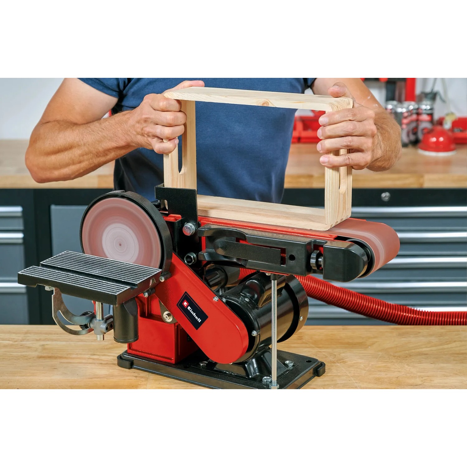 Einhell TC-US 380 levigatrice a nastro e disco da banco mentre leviga una cornice di legno.
