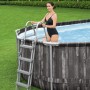 Piscina fuori terra ovale effetto legno con scaletta. Donna che entra in piscina.