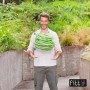 Uomo che tiene in mano un tubo per irrigazione t.b.t. verde arrotolato.