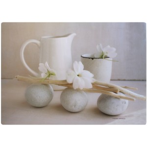 Tovaglia con natura morta: brocca bianca, tazza, pietre, rami e fiori. Biancheria da tavola decorativa.