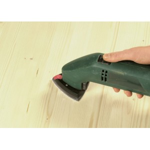 Tampone abrasivo LUX K80 per levigatrice triangolare (96mm) in uso su legno.