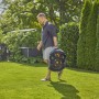 Uomo che trasporta il robot tagliaerba t.b.t. in giardino.