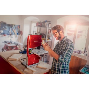 Sega a nastro Einhell TC-SB 200/1 in uso: sega a nastro rossa taglia legno in officina.