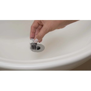 Mano inserisce sifone t.b.t. nel lavandino. Sifone per lavabi.