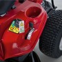 Dettaglio: Tosaerba rider Troy-Bilt Mini-Rider 76T-S rosso con scarico laterale, con focus su comandi e pneumatico.