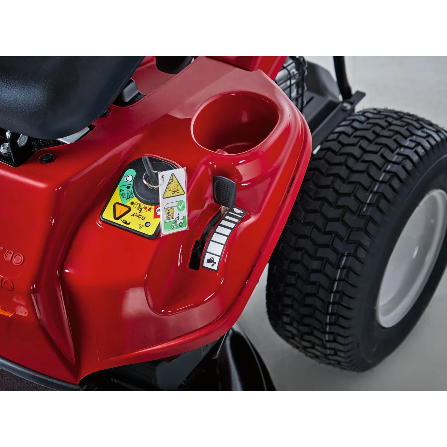 Dettaglio: Tosaerba rider Troy-Bilt Mini-Rider 76T-S rosso con scarico laterale, con focus su comandi e pneumatico.