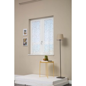 Tenda a rete decorativa e trasparente sulla finestra con tavolino e lampada da terra.