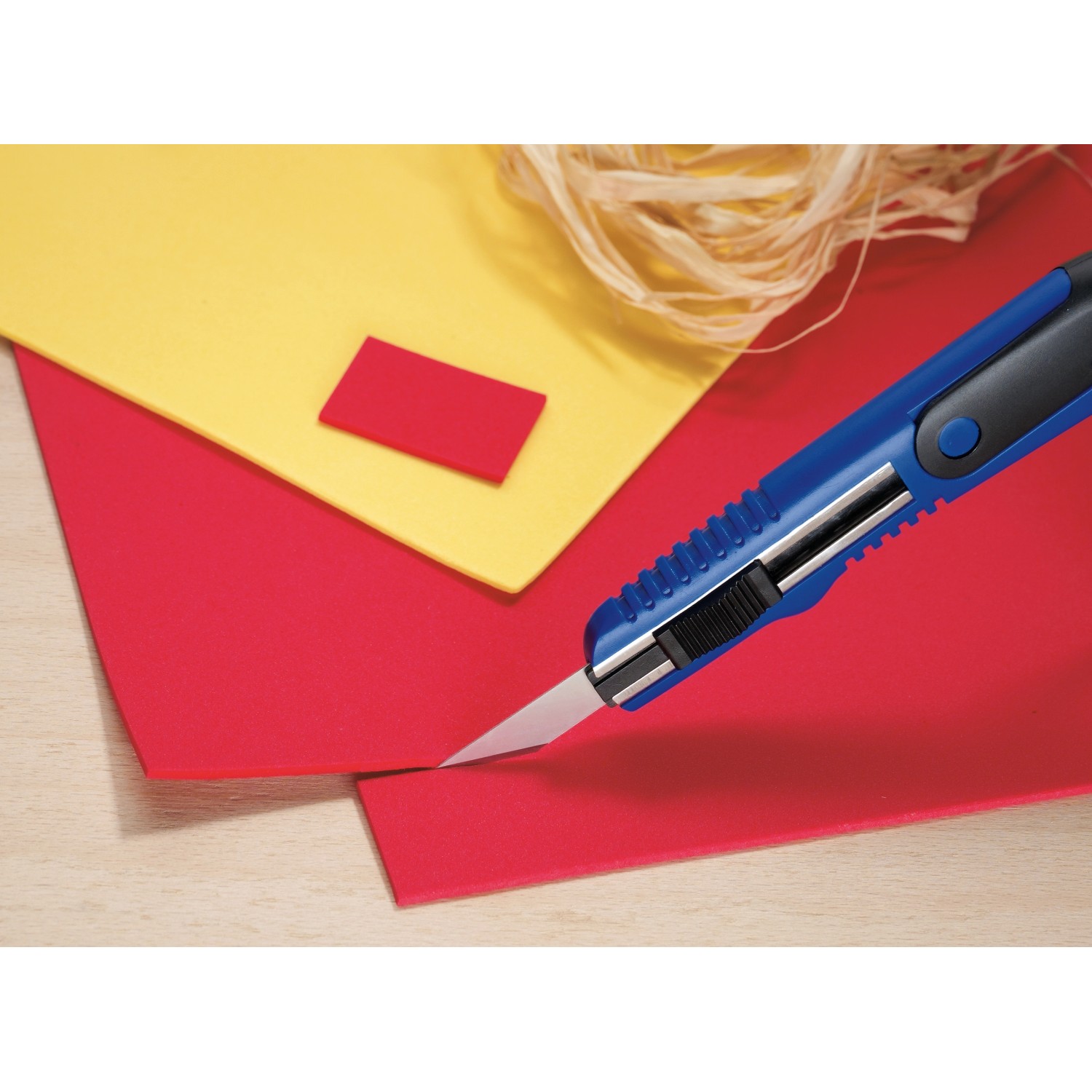 Coltello di precisione LUX Classic taglia pannello rosso, pannello giallo sullo sfondo.