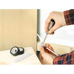 Utilizzo del set di installazione: tester di tensione, morsettiera e nastro isolante in uso.
