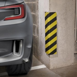 Protezione angolare gialla e nera di t.b.t. accanto a un'auto in un garage.