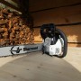 Motosega t.b.t. davanti a catasta di legna. Potente per giardino e bosco.