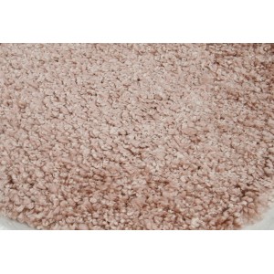 Dettaglio di un tappeto a pelo lungo rotondo beige.