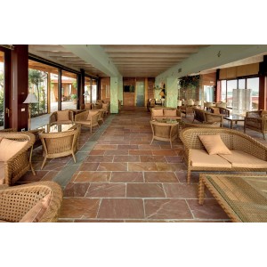 Patio con pavimentazione t.b.t. e mobili in rattan.