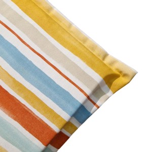 Dettaglio di un cuscino da esterno a righe nei toni del giallo, blu e arancione.