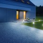Lampada da giardino Steinel LED Bluetooth GL 80 antracite illuminata lungo un vialetto pavimentato.