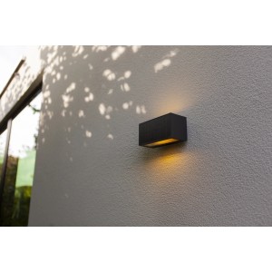 Applique solare t.b.t. nera su una parete. Forma rettangolare, luce calda.