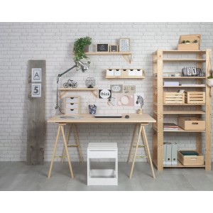 Ufficio domestico con scrivania in legno, scaffale e sgabello bianco su muro di mattoni.