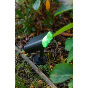 Lutec Ginbo, lampada solare LED nera con luce verde in giardino.