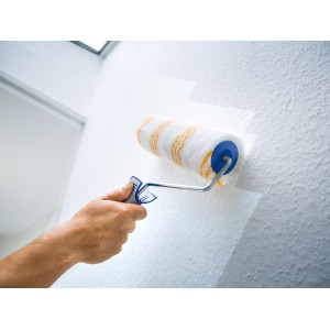 Rullo per pittura LUX 25cm mentre dipinge una parete strutturata.