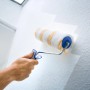 Rullo per pittura LUX 25cm mentre dipinge una parete strutturata.