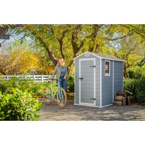 Casetta da giardino in plastica Keter grigia (2,17 m²) con bicicletta e donna in giardino.