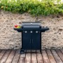 Barbecue a gas nero t.b.t. con ripiani e mobile base davanti a muro di pietra.