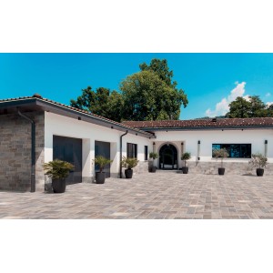 Area esterna con piastrelle per pavimenti t.b.t. effetto pietra, posate su una terrazza davanti a una casa.