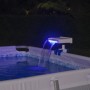Cascata per piscina Flowclear™ con luce LED fissata al bordo piscina, illuminata di blu.